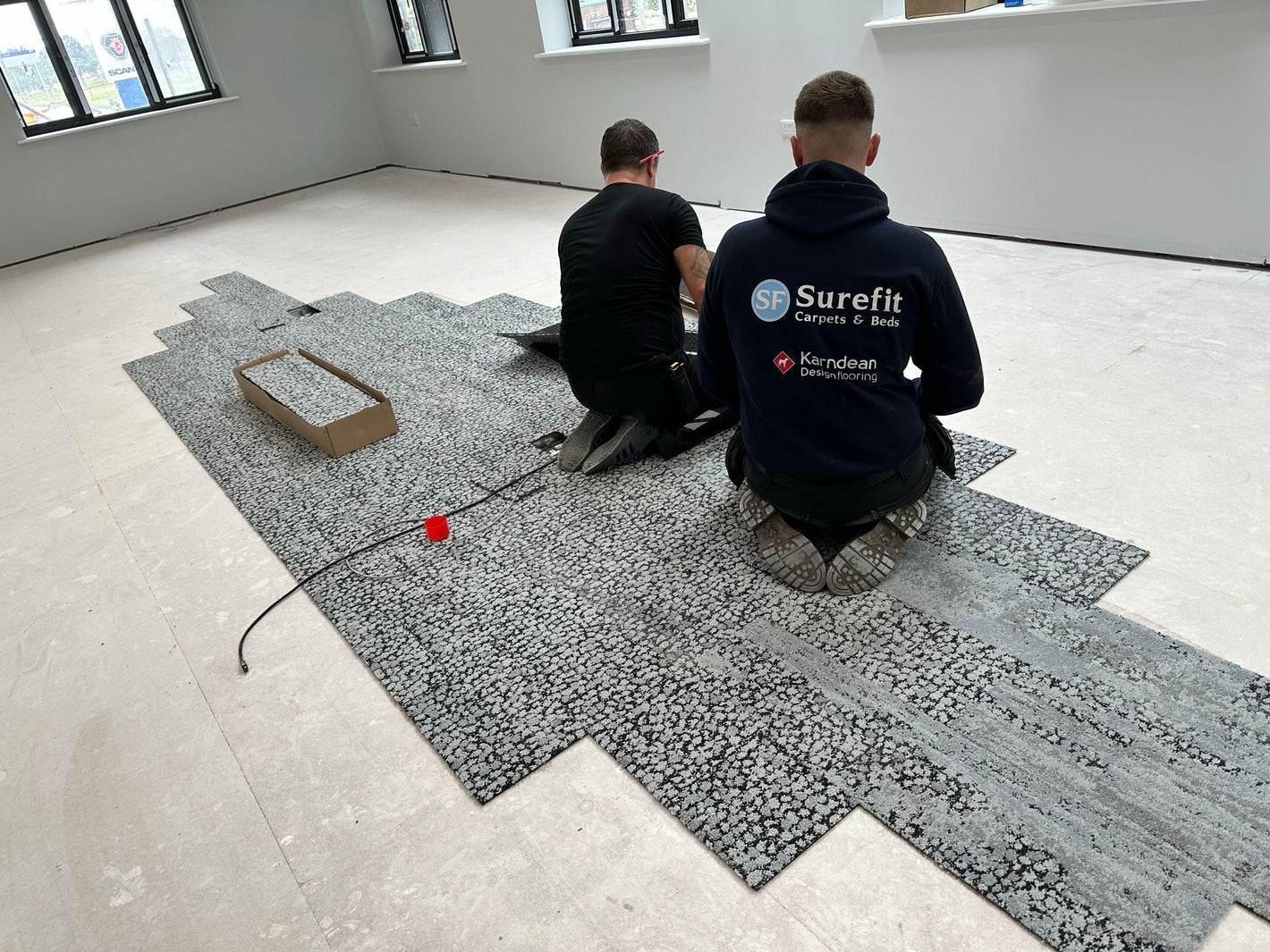 Surefit Carpets expert fitters installing Carpet Tiles in a commercial property.